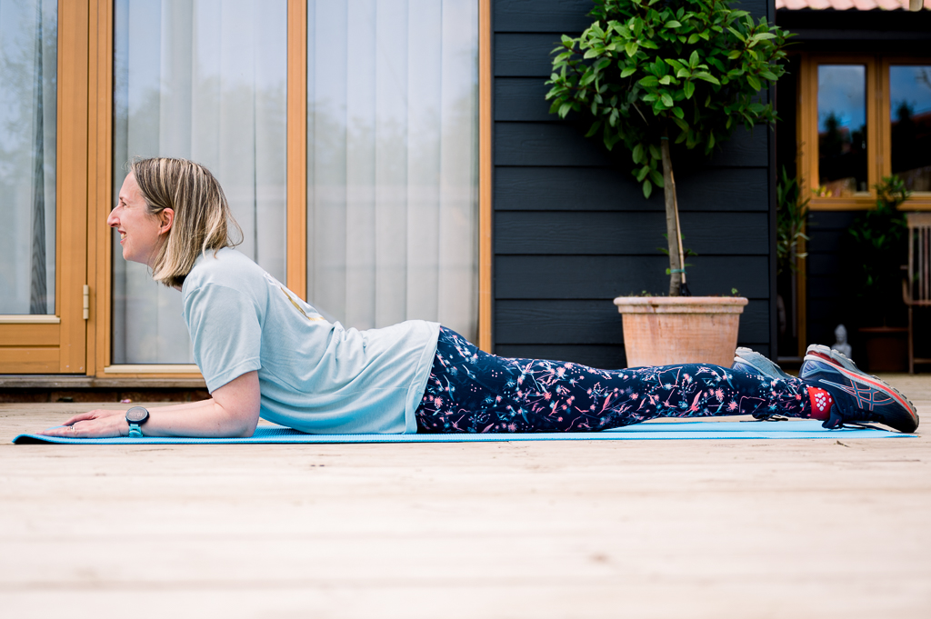 Fitness business showing a lady with gym clothes on lying down on a yoga mat stretching