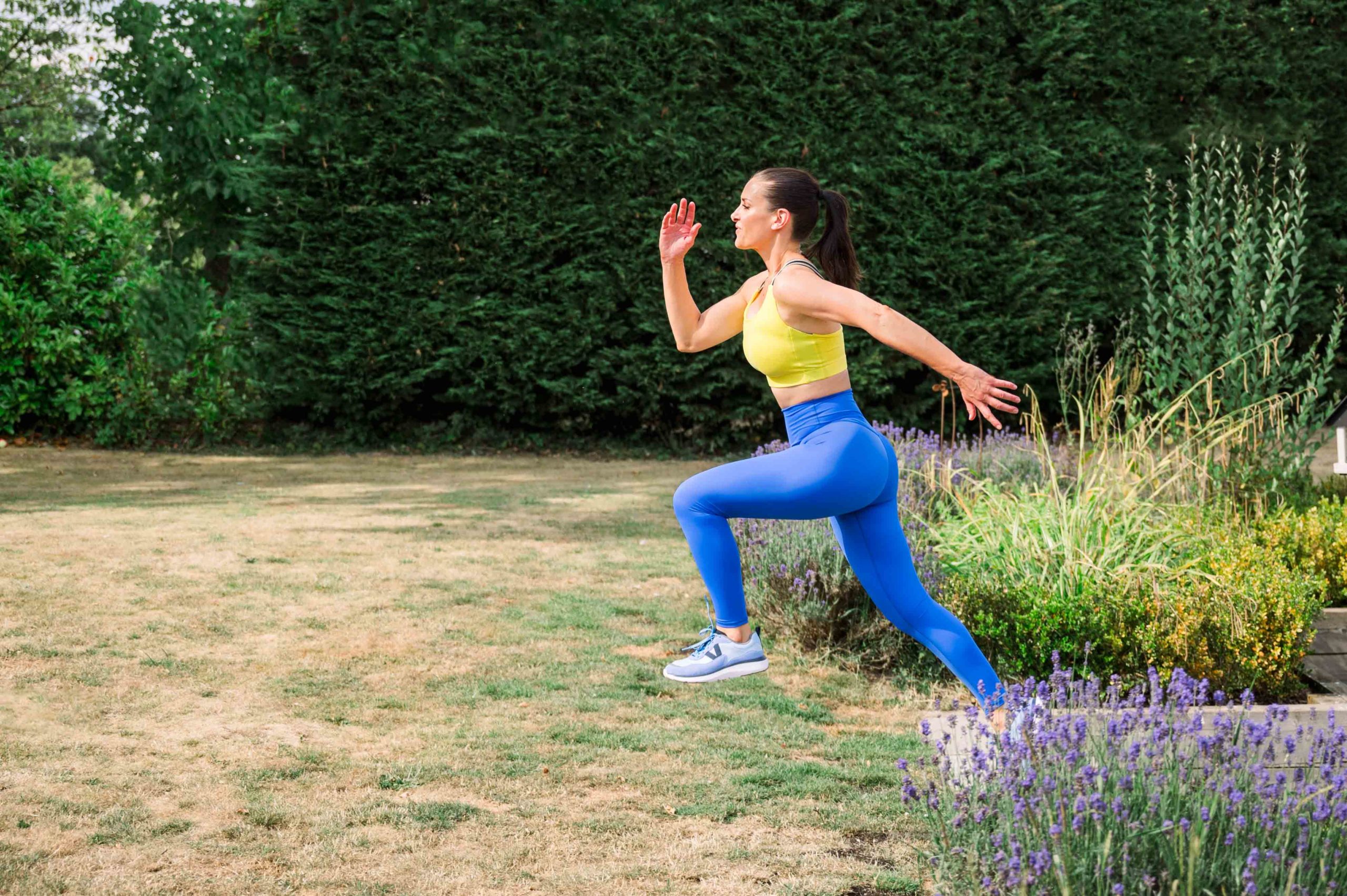 Brown haired lady running in a yellow top and blue leggings